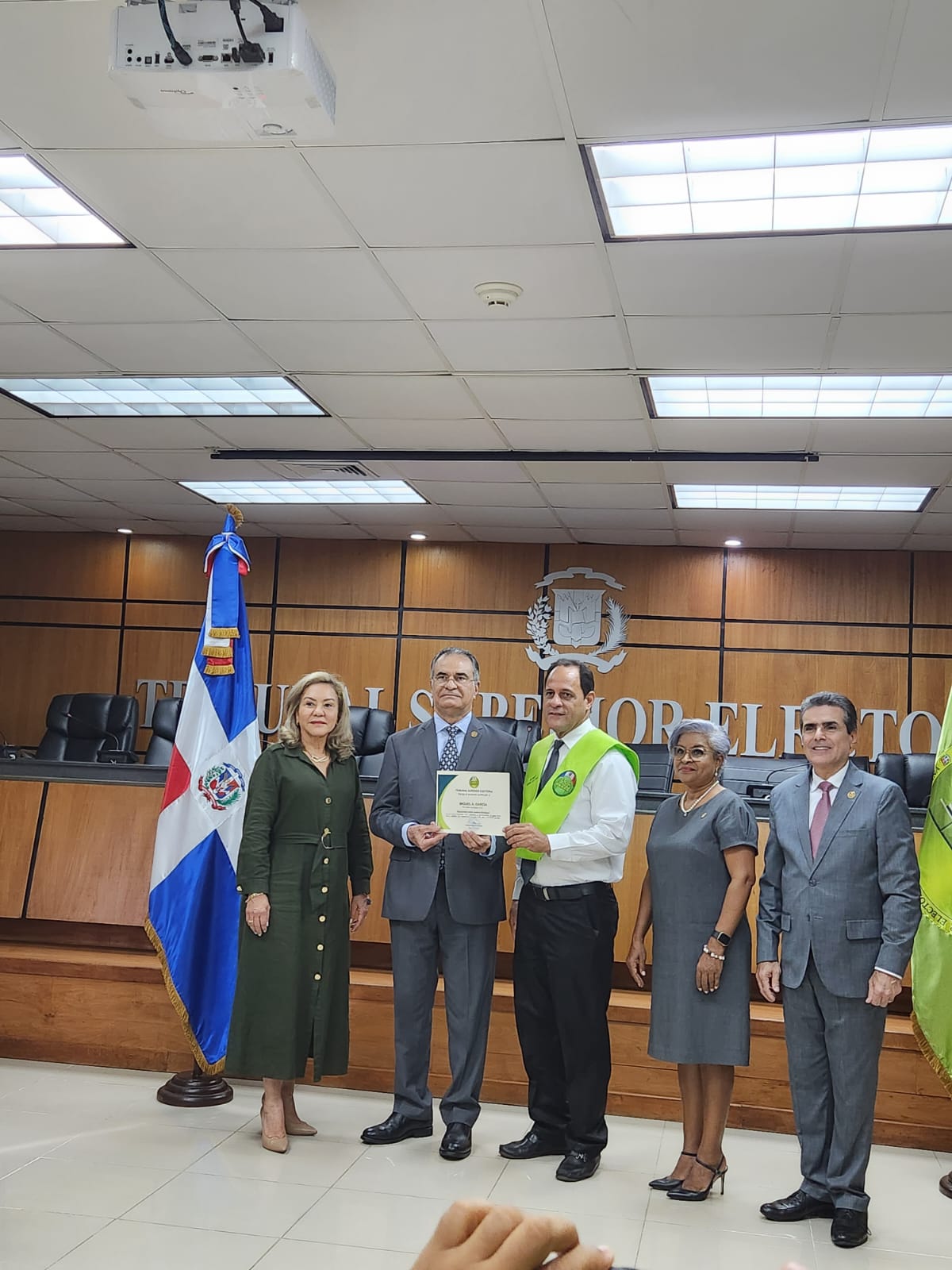 El licenciado Miguel García, recibe el certificado.