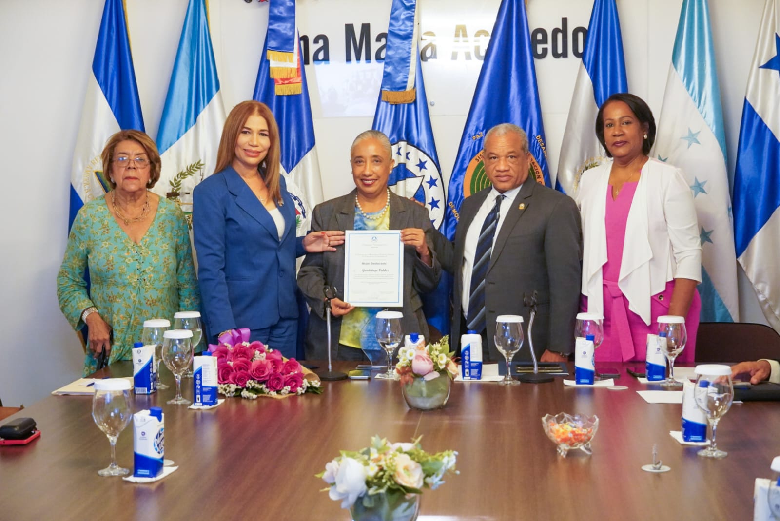 La presidenta de la Comisión de la Mujer, Niñez, Juventud y Familia del PARLACEN, Silvia García, entrega, junto a los también diputados Eduardo Rey Guerrero y Xiomara Guante, y la presidenta del Foro de Mujeres de Partidos políticos de la República Dominicana, doctora María Rosa Belliard, el certificado de reconocimiento a la licenciada Guadalupe Valdez.